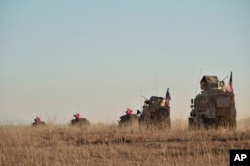 FILE - Turkish and U.S. troops conduct joint patrols around the Syrian town of Manbij, as part of an agreement that aimed to ease tensions between the two NATO allies, Nov. 1, 2018.