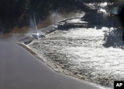 Floodwaters rush over a diversion dam in Columbia, S.C., Oct. 6, 2015. Despite an improving forecast, it will still take weeks for the state to return to normal after being pummeled by a historic rainstorm.