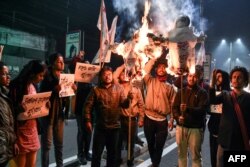 Student activists burn effigies of India's prime minister and chief minister of Assam in Guwahati, India, on Jan, 8, 2019, after India's lower house passed legislation that will grant citizenship to members of certain religious minorities but not Muslims.