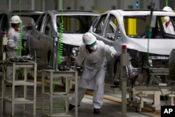 FILE - Employees work in the multibillion-dollar Honda car plant in Celaya, in the central Mexican state of Guanajuato, Feb. 21, 2014.