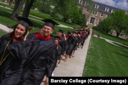 FILE: Barclay College graduates Taylor Mabry and Ryan Kucharek walk across campus to commencement ceremonies. Haviland, Kansas. May 2019