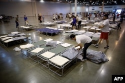 Para relawan mempersiapkan tempat tidur tambahan untuk para pengungsi Badai Harvey di NRG Center, Houston, Texas, 31 Agustus 2017.