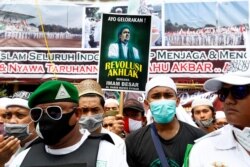 Orang-orang berkumpul untuk menyambut kepulangan Rizieq Shihab, pemimpin Front Pembela Islam Indonesia (FPI) yang telah menetap di Arab Saudi sejak 2017, Jakarta, 10 November 2020. (Foto: REUTERS/Ajeng Dinar Ulfiana)