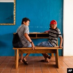 Students in El Cuco, El Salvador, try out a bench and desk made by Surf for Life members Danny Hess and Jay Nelson.
