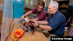 Student William Godsey, left, and Bradley Miller, associate director of WPI’s Robotics Resource Center, examine the lionfish harvesting robot built by Godsey and his team. (Worcester Polytechnic Institute)