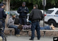 Police officers arrest two men who attacked a student on the University of California, Berkeley campus in Berkeley, Calif., Feb. 2, 2017.