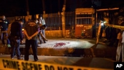 FILE - Bangladeshi policemen investigate at the site of attack on Bangladeshi-American blogger Avijit Roy, in Dhaka, Bangladesh, Feb. 26, 2015.