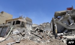Iraqis clear the debris of a building in west Mosul on June 3, 2017, after it was retaken by government forces during their ongoing battle against Islamic State (IS) group fighters.
