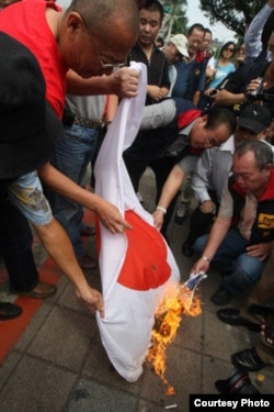 抗议者在台湾立法院外焚烧日本国旗(中央社)