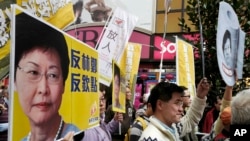 Protesters raise placards and banner during a rally against Hong Kong's former Chief Secretary Carrie Lam in Hong Kong, Feb. 5, 2017.