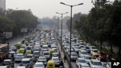 FILE - Vehicles move slowly at a traffic intersection after the end of a two-week experiment to reduce the number of cars to fight pollution in in New Delhi, India, Jan. 16, 2016.