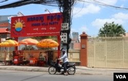 បុរសម្នាក់ឈប់ម៉ូតូនៅខាងមុខទីស្នាក់ការគណបក្សឆន្ទៈខ្មែរក្នុងខណ្ឌចំការមន ដែលកំពុងបិទទ្វារ នាថ្ងៃបើកយុទ្ធនាការថ្ងៃទី១នៃការឃោសនារកសំឡេងគាំទ្រសម្រាប់ការបោះឆ្នោតជ្រើសរើសក្រុមប្រឹក្សា អាណត្តិទី៣ នៅថ្ងៃទី១៧ ខែឧសភា ឆ្នាំ២០១៩។ (កាន់ វិច្ឆិកា/VOA Khmer)