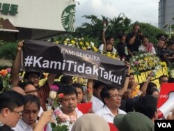 A banner reading "We Are Not Afraid" is held aloft during a vigil at the site of the Jakarta terrorist attack, Jakarta, Indonesia, Jan. 15, 2016. (S. Herman/VOA News)