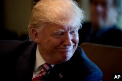 President Donald Trump smiles during a Cabinet meeting, June 12, 2017, in the Cabinet Room of the White House in Washington.