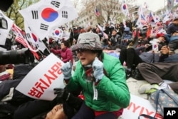 박근혜 전 한국 대통령 1심 선고일인 6일 서울중앙지법 앞에서 박 전 대통령의 지지자들이 1심 선고 결과를 확인한 뒤 눈물을 흘리고 있다.