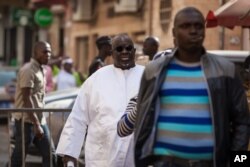 Papa Massata Diack, au centre, fils de l'ancien président de l'IAAF Lamine Diack arrive au commissariat central de Dakar, au Sénégal, lundi 17 février 2016.