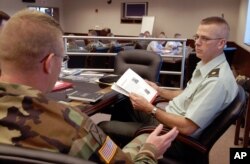 Major Jeff Jennings, right, talks with Captain Joseph Scanlin before the start of a talk by writer McKay Jenkins during a workshop sponsored by the National Endowment for the Arts at the 10th Mountain Division in Fort Drum, N.Y., June 5, 2004. While in Afghanistan, Jennings sent home descriptive emails to his wife called "News from the Edge of the Empire." The emails became so widely circulated that West Point cadets were given some of them as assigned reading. Dubbed "Operation Homecoming" by the NEA, about 45 soldiers sat through the first session.