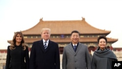 President Donald Trump, second left, first lady Melania Trump, left, Chinese President Xi Jinping, second right, and his wife Peng Liyuan, right, stand together as they tour the Forbidden City, Nov. 8, 2017, in Beijing, China.