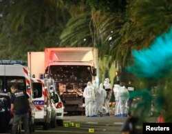 French police force and forensic officers early Friday look at the truck that ran into a crowd celebrating the Bastille Day national holiday in Nice, France, July 14, 2016.