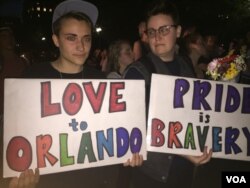 Attendees at the vigil hold signs in support of the victims of the Orlando attack. (K. Gypson/VOA)