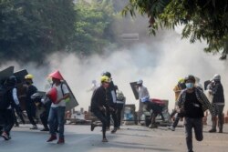 Pengunjuk rasa kudeta anti-militer melarikan diri dari gas air mata yang ditembakkan oleh polisi dan tentara di Mandalay, Myanmar, 3 Maret 2021. (Foto: AP)