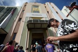 Ricardo Castellanos stands at a Wi-Fi hot spot in the aftermath of Hurricane Maria with many cellphone towers down in San Juan, Puerto Rico, Sept. 24, 2017.