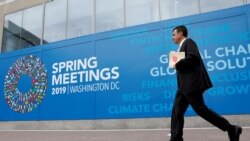 FILE - A man walks outside the International Monetary Fund headquarters building ahead of the IMF/World Bank spring meetings in Washington, Apr. 8, 2019.