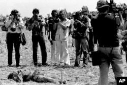 Wartawan memotret tubuh di daerah Saigon pada awal 1968, selama Serangan Tet. (Foto: AP/Nick Ut)