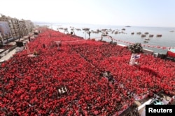 FILE - Turkish President Recep Tayyip Erdogan greets AK Party and Nationalist Movement Party (MHP) supporters during a rally for the upcoming local elections, in Izmir, Turkey, March 17, 2019.