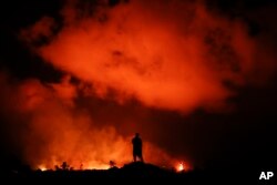 Peter Vance, 24, photographs lava erupting in the Leilani Estates subdivision near Pahoa, Hawaii, May 18, 2018.