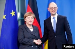 German Chancellor Angela Merkel, left, and Ukraine's Prime Minister Arseniy Yatsenyuk appear after talks at the chancellery in Berlin, April 1, 2015.