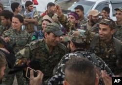 Members of the U.S.-backed Syrian Democratic Forces (SDF) dance a traditional Syrian "Dabka" as they celebrate in front of stadium that was the site of Islamic State fighters' last stand in the city of Raqqa, Syria, Oct. 20, 2017.