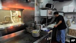 FILE - Carlos Chavez, works in the kitchen by of his restaurant by himself on "A Day Without Immigrants," July 1, 2011, in Atlanta. Chavez gave his workers the day off, however with other restaurant owners open he decided he couldn't afford to remain clos