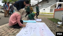 Mahasiswa Universitas Sumatera Utara (USU) saat menandatangani seruan penolakan terhadap tindak pelecehan seksual di kampus, Jumat (21/6). (VOA/Anugrah Andriansyah)