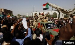 Sudanese soldiers are seen on their vehicles as they move with a military convoy outside the defense ministry compound in Khartoum, Sudan, April 25, 2019.