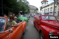 Tourists enjoy a ride in vintage cars in old Havana, Cuba, Jan. 17, 2016.
