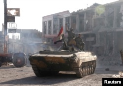 FILE - Syrian troops roll into the center of Qusair June 5, 2013, after capturing the stragegic town with key help from Lebanese Hezbollah fighters.