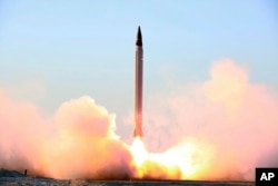 This picture released by the official website of the Iranian Defense Ministry, Oct. 11, 2015, claims to show the launching of an Emad long-range ballistic surface-to-surface missile in an undisclosed location.