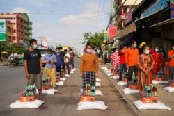 Workers receive food donations inside a 'red zone', which has stricter lockdown measures imposed due to the coronavirus disease (COVID-19) outbreak, in Phnom Penh, Cambodia, April 28, 2021. REUTERS/Cindy Liu