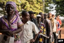 FILE - Voters queue outside a polling station in Bangui on Dec. 13, 2015 to vote for the constitutional referendum, seen as a test run for upcoming presidential and parliamentary polls.