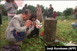 Russia -- Japanese people praying at a cemetery on the Kuril Islands. September 03, 1989