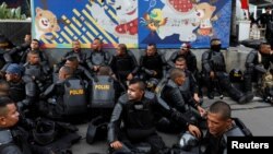 Police officers rest during a protest following the announcement of last month's election official results outside Indonesia's Election Supervisory Agency headquarters in Jakarta, Indonesia, May 22, 2019.