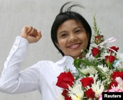 FILE - Thai media activist Supinya Klangnarong celebrates at the criminal court in Bangkok, March 15, 2006.
