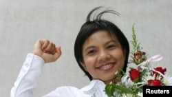 FILE - Thai media activist Supinya Klangnarong celebrates at the criminal court in Bangkok, March 15, 2006.