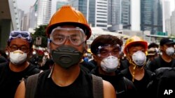 Protesters wearing protection gears march toward the Legislative Council as they continue to protest against the extradition bill in Hong Kong, Monday, June 17, 2019. (AP Photo/Vincent Yu)