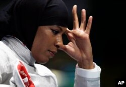 Ibtihaj Muhammad of the United States reacts after losing against Cecilia Berder of France in the women's individual saber fencing event at the 2016 Summer Olympics in Rio de Janeiro, Brazil, Aug. 8, 2016.