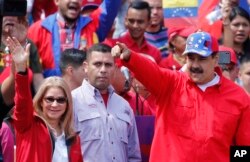 President Nicolas Maduro and first lady Cilia Flores greet supporters as they arrive at a rally in Caracas, Feb. 2, 2019.