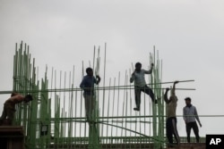 Laborers work at a building site in Mumbai, India, in late November, 2021.
