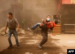 A member of the Syrian Civil Defence carries an injured child following regime airstrikes on the rebel-held besieged town of Douma in the eastern Ghouta region, Feb. 7, 2018.