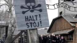 Germany's President Frank-Walter Steinmeier, center, and his wife Elke Buedenbender enter the Auschwitz I Nazi death camp in Oswiecim, Poland, Monday, Jan. 27, 2020.